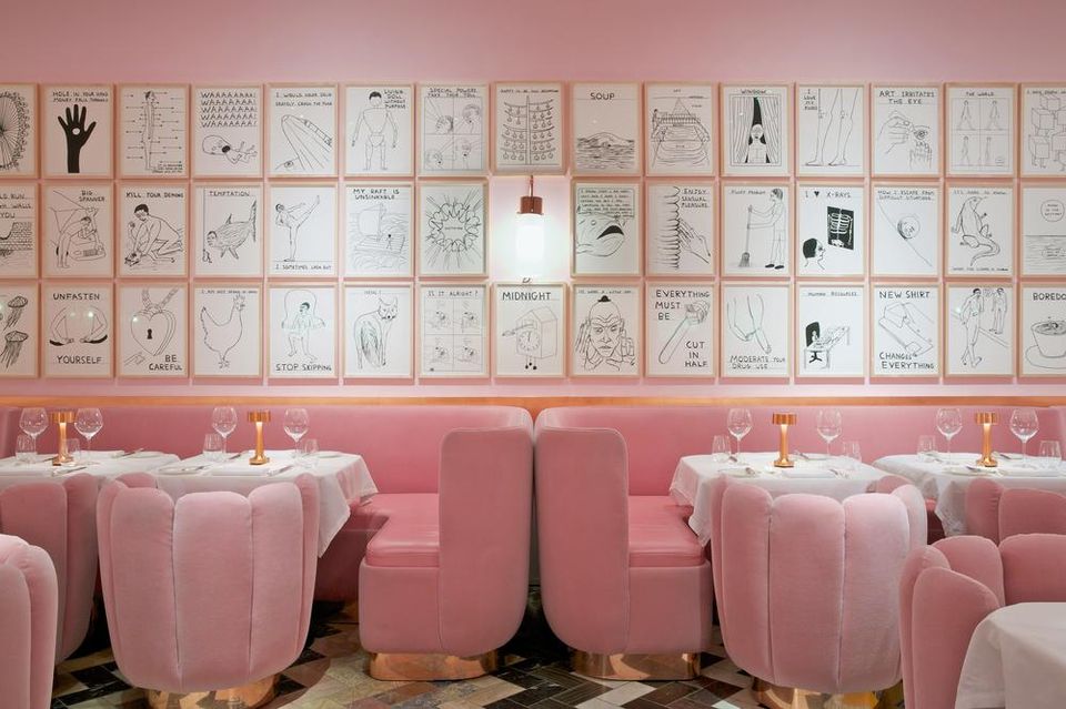 light pink tables and chairs in soothing restaurant with black and white sketches on wall